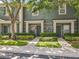 Charming townhome featuring lush landscaping, muted blue exterior, and inviting entryway at 3309 Wilshire Way Rd # 3, Orlando, FL 32829