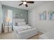 Stylish bedroom with a plush white bed, a ceiling fan, and calming blue accent wall at 341 Burma St, Kissimmee, FL 34747