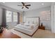 The neutral-toned main bedroom features a large platform bed, ceiling fan and modern decor at 341 Burma St, Kissimmee, FL 34747
