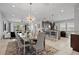 Open-concept dining room and kitchen area featuring modern lighting and a large island at 341 Burma St, Kissimmee, FL 34747