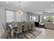 Open-concept living space with a dining area with a modern chandelier and gray upholstered chairs at 341 Burma St, Kissimmee, FL 34747