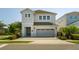Charming two-story home featuring a gray garage door, brick driveway, and manicured landscaping at 341 Burma St, Kissimmee, FL 34747