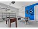 Bright garage featuring a foosball table, air hockey table and a playful blue accent wall with wall decor at 341 Burma St, Kissimmee, FL 34747