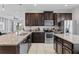 Spacious kitchen featuring dark cabinetry, granite countertops, and stainless steel appliances at 341 Burma St, Kissimmee, FL 34747
