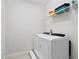 Efficient laundry room with a washer and dryer, featuring storage shelves for convenience and organization at 341 Burma St, Kissimmee, FL 34747