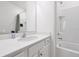 Bright bathroom featuring a white vanity with solid surface countertop and a tiled shower tub combo at 3860 Sonoma Blvd, Kissimmee, FL 34741