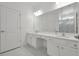 Bright bathroom featuring double sinks, white cabinetry, and a glass shower at 3860 Sonoma Blvd, Kissimmee, FL 34741