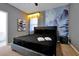 Modern bedroom with a large black bed, stylish nightstand, and serene mural at 3860 Sonoma Blvd, Kissimmee, FL 34741