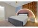 Modern bedroom featuring a plush bed with stylish headboard, unique wall design, and contemporary bedside table at 3860 Sonoma Blvd, Kissimmee, FL 34741