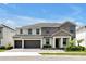 Beautiful two-story home showcasing neutral paint, a three-car garage, manicured landscaping, and a tile roof at 3860 Sonoma Blvd, Kissimmee, FL 34741
