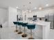 A bright, modern kitchen featuring white cabinets, stainless steel appliances, marble floors, and pendant lighting at 3860 Sonoma Blvd, Kissimmee, FL 34741