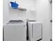 Bright laundry room featuring a front load washer and dryer with a wire rack shelf above at 3860 Sonoma Blvd, Kissimmee, FL 34741