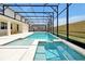 Aerial view of pool and spa with screened-in enclosure and outdoor dining area at 3860 Sonoma Blvd, Kissimmee, FL 34741