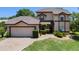 Charming two-story home with a tile roof, brick driveway, and lush green lawn at 4019 Lake Mirage Blvd, Orlando, FL 32817
