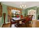 Dining room with a large wooden table, red chairs, and a window with floral curtains at 4571 Abaco Dr, Tavares, FL 32778