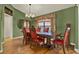 Dining area with a wooden table, six red chairs, a chandelier, and hardwood floors at 4571 Abaco Dr, Tavares, FL 32778