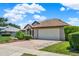 Traditional home with a brick driveway, a two-car garage, and lovely front yard landscaping at 4571 Abaco Dr, Tavares, FL 32778