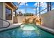 A luxurious hot tub with a unique rock waterfall, tile surround, and partial screened enclosure at 4571 Abaco Dr, Tavares, FL 32778