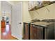 Laundry room featuring modern stainless steel Samsung washer and dryer, with wood floors visible through open door at 4571 Abaco Dr, Tavares, FL 32778