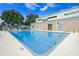 Community swimming pool with clear blue water and surrounding lounge chairs under a blue sky at 4571 Abaco Dr, Tavares, FL 32778