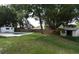The expansive backyard features a shed and mature trees, providing privacy and shade at 5805 Hutton Dr, Orlando, FL 32808