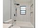 This renovated bathroom features modern tile, a bathtub and shower combo, and a window for natural light at 5805 Hutton Dr, Orlando, FL 32808