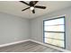 Bright bedroom with new vinyl floors, fresh paint, a ceiling fan, and natural light from the window at 5805 Hutton Dr, Orlando, FL 32808