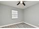 This bedroom features wood-look floors, a window, gray walls, white trim, and a ceiling fan with light fixture at 5805 Hutton Dr, Orlando, FL 32808