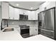 Beautiful kitchen features white cabinets, stainless steel appliances, quartz countertops, and a modern faucet at 5805 Hutton Dr, Orlando, FL 32808