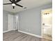 Spacious bedroom with light gray walls, new vinyl floors, a ceiling fan, and an ensuite bathroom at 5805 Hutton Dr, Orlando, FL 32808
