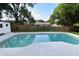 A private pool with a concrete deck is surrounded by lush greenery and a wooden fence at 5805 Hutton Dr, Orlando, FL 32808