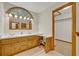 Bright bathroom featuring double sinks, wooden cabinets, and a large arched window for natural light, plus adjacent closet at 595 Seminole Woods Blvd, Geneva, FL 32732