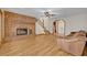 Cozy living room with hardwood floors, brick fireplace, and natural lighting at 595 Seminole Woods Blvd, Geneva, FL 32732