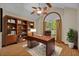 Home office with a large window, built-in bookcase, hardwood floors, ceiling fan and a wooden desk at 595 Seminole Woods Blvd, Geneva, FL 32732