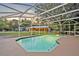 Inviting screened-in pool with view of the house and adjacent covered horse stables at 595 Seminole Woods Blvd, Geneva, FL 32732