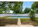 Backyard showcasing a rectangular in-ground pool surrounded by a white fence and green lawn at 6 S Lakewood Dr, Orlando, FL 32803