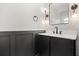This half bath has black fixtures, modern vanity, white countertop and walls, and a modern mirror and lighting at 612 Florida Ave, St Cloud, FL 34769