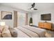 This bedroom offers a cozy space with a ceiling fan, mounted TV, and natural light from the window at 612 Florida Ave, St Cloud, FL 34769