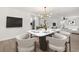 Open-concept dining room featuring a marble table, modern light fixture, and kitchen access at 612 Florida Ave, St Cloud, FL 34769