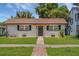 Charming single-story home with a light-brick exterior, well-manicured lawn, and inviting entrance at 612 Florida Ave, St Cloud, FL 34769