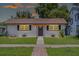 Charming single-story home featuring a manicured lawn and a welcoming entrance with decorative pergola at 612 Florida Ave, St Cloud, FL 34769