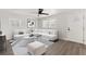 Bright living room with neutral tones featuring a white sofa, modern art, and a ceiling fan at 612 Florida Ave, St Cloud, FL 34769
