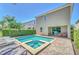 Backyard features a pool, spa, covered patio, hedges and lounge chairs at 640 Lasso Dr, Kissimmee, FL 34747