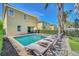 Backyard features a pool, spa, covered patio, hedges and lounge chairs at 640 Lasso Dr, Kissimmee, FL 34747