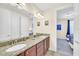 Well lit bathroom featuring a double vanity, granite countertops, and two sinks at 640 Lasso Dr, Kissimmee, FL 34747