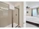 Bathroom shower stall with beige tiling and seamless glass doors at 640 Lasso Dr, Kissimmee, FL 34747