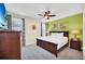 Bedroom featuring a king-sized bed, neutral walls and carpet, and green accent wall at 640 Lasso Dr, Kissimmee, FL 34747