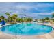 Large swimming pool with a waterslide, surrounded by palm trees and plenty of lounge chairs at 640 Lasso Dr, Kissimmee, FL 34747