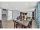 Open-concept dining area features a large glass table, tile flooring, and seamless access to the kitchen and staircase at 640 Lasso Dr, Kissimmee, FL 34747