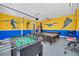 Spacious game room featuring a foosball table, ping pong table, and vibrant wall decor at 640 Lasso Dr, Kissimmee, FL 34747